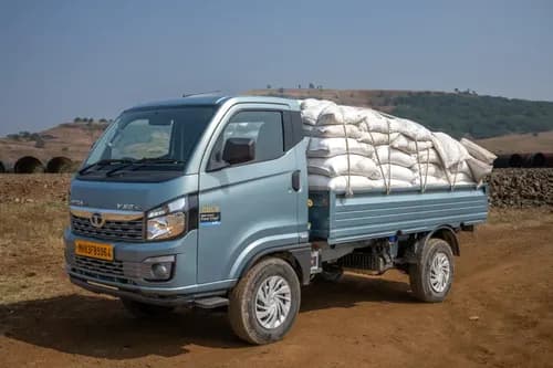 Tata Intra V50 Gold front three-quarter loaded view - cargo transport on dirt road mini truck India 2026