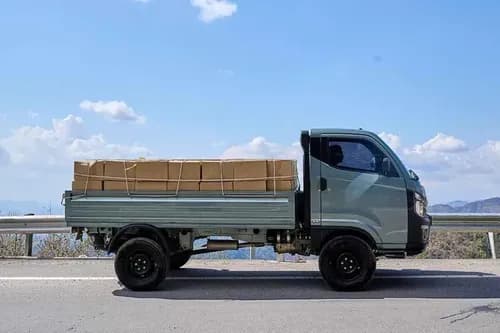 Tata Intra V50 LNT right side profile view - loaded flatbed coastal highway mini truck India 2026